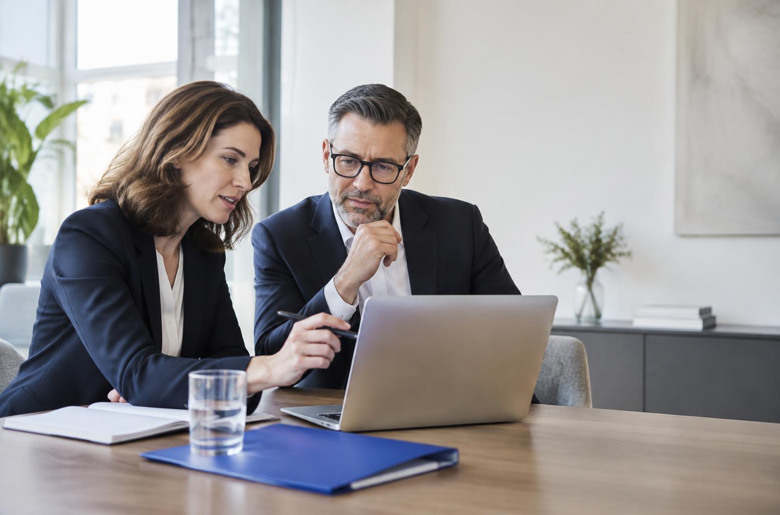 Zwei Fachleute arbeiten gemeinsam an einem Laptop